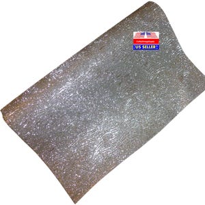 May include: Silver glitter fabric with a subtle wave pattern. The fabric is smooth and shiny, with a fine glitter finish.  "CraftyVintageSupply US SELLER" is printed on a red, white, and blue label.