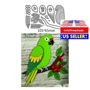 以下が含まれることがあります： 黄色と赤のアクセントが付いた緑色のオウムのダイカット。赤いベリーと緑の葉が付いた茶色の枝にとまっています。ダイカットのサイズは10.5cm x 6.5cmです。画像にはダイカットテンプレートも表示されています。
