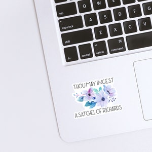 May include: A white laptop with a sticker that says "Thou may ingest a satchel of Richards" with a watercolor floral design in shades of blue, purple, and pink.