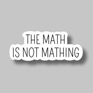 May include: White sticker with the phrase "THE MATH IS NOT MATHING" in black, sans-serif font. The sticker has a rounded, cloud-like shape and a subtle shadow, set against a gray background. A humorous, relatable item.