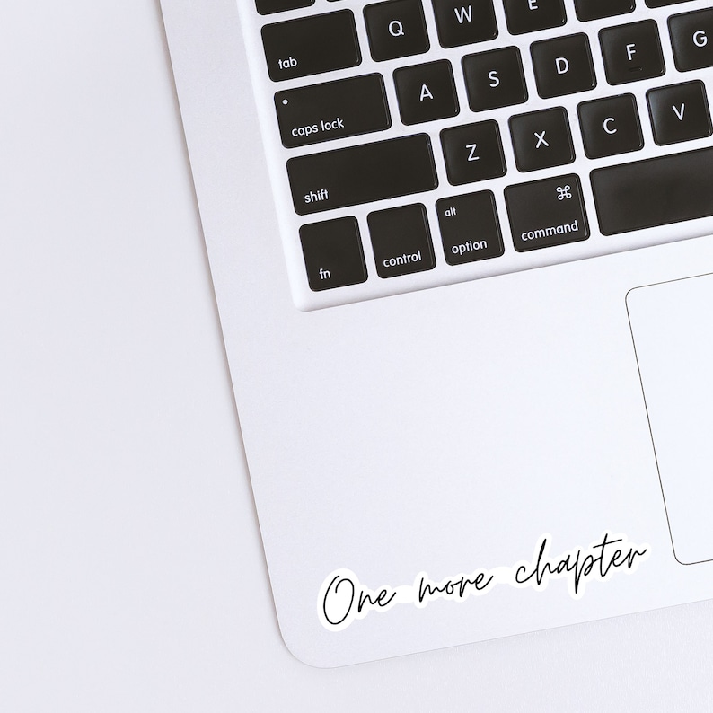 Op de afbeelding: Een witte laptop met een zwart toetsenbord en een sticker met de tekst "One more chapter" in de rechterbenedenhoek.