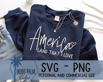 May include: A navy blue sweatshirt with the words "America LAND THAT I LOVE" in white script. A silver necklace with a pendant rests on the shirt. The image also includes a pair of jeans and the text "SVG - PNG PERSONAL AND COMMERCIAL USE".