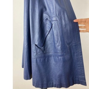 May include: A dark blue leather jacket with a single pocket on the front.
