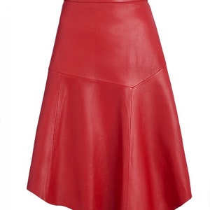 Pu&ograve; includere: Una gonna in pelle rossa vibrante con una silhouette svasata a trapezio. La gonna presenta una fascia in vita aderente e un design a pannelli unico, creando un look elegante e moderno. Questa gonna &egrave; una audace dichiarazione di moda.