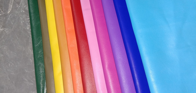 Pu&ograve; includere: Una collezione di fogli di pelle colorati in varie tonalit&agrave;, tra cui verde, giallo, arancione, rosso, rosa, viola e blu. I fogli sono disposti uno accanto all'altro, mostrando uno spettro di colori e texture, adatti per l'artigianato.