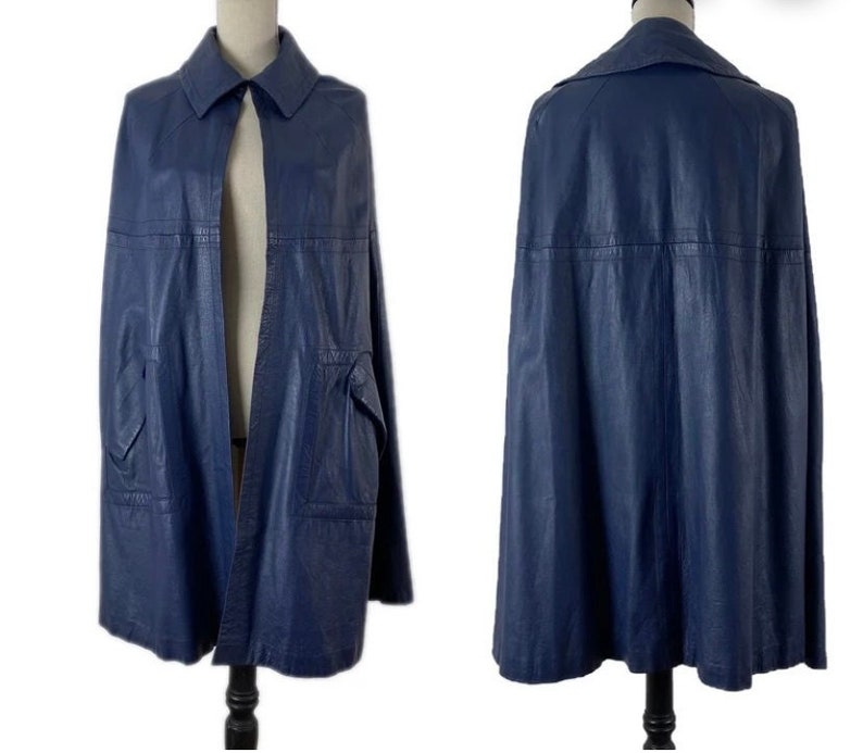 May include: A blue leather cape with a collar and a single button closure. The cape has a pocket on each side and is lined with a smooth fabric.