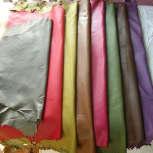 Pode incluir: Uma cole&ccedil;&atilde;o de nove amostras de couro em v&aacute;rias cores, incluindo cinza, vermelho, amarelo, marrom, rosa, verde, marrom escuro e roxo. As amostras est&atilde;o dispostas em uma fila, com a amostra cinza na parte superior e a amostra roxa na parte inferior.