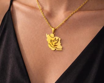 May include: Gold-colored necklace featuring a pendant shaped like a country map with a dove and olive branch design. The pendant hangs from a delicate chain, creating a stylish accessory.