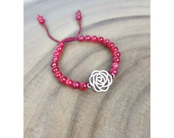 May include: A red beaded bracelet with a silver rose charm. The bracelet is adjustable and has a simple design.