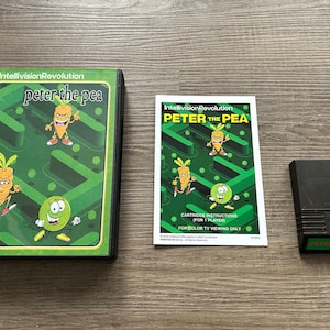 May include: A vintage Intellivision video game set featuring "Peter the Pea." The set includes the game cartridge, instruction manual, and game box. The box and manual feature cartoon illustrations of a carrot and a pea.