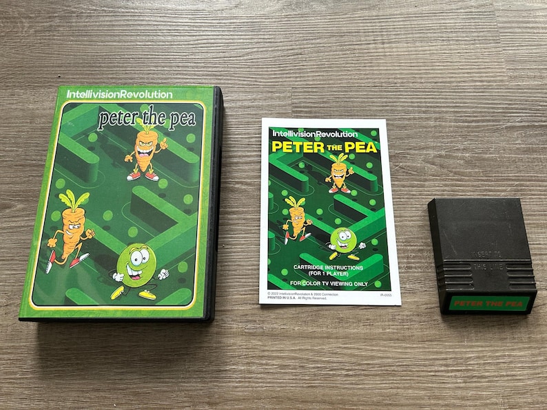 May include: A vintage Intellivision video game set featuring "Peter the Pea." The set includes the game cartridge, instruction manual, and game box. The box and manual feature cartoon illustrations of a carrot and a pea.