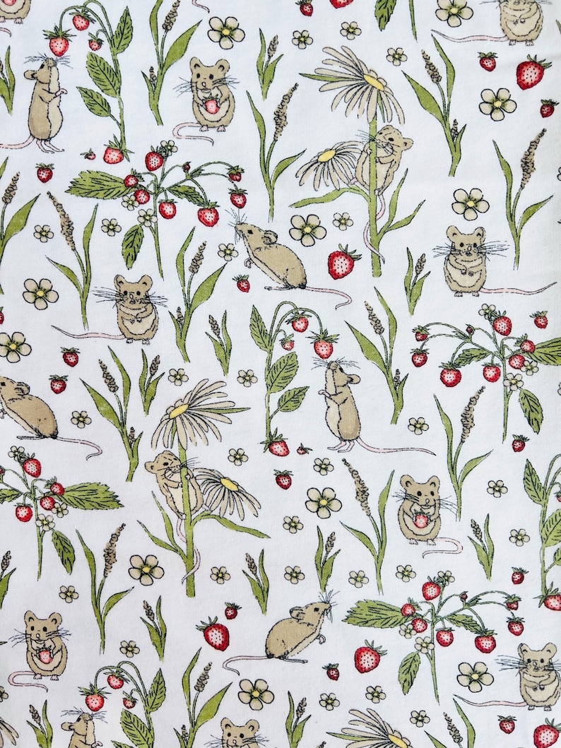 Op de afbeelding: Een witte stof met een herhalend patroon van bruine muizen, groene planten, rode aardbeien en witte bloemen.