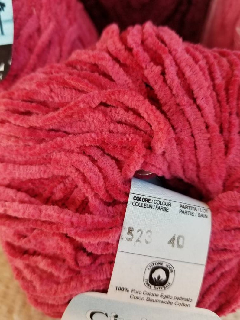 Pu&ograve; includere: Un gomitolo di filato di cotone rosa intenso con un'etichetta che recita "COLORE/COLOUR COULUER/FARBE PARTITA/LOT PARTIE/BAIN 523 40 COTONE 100% TOMA NATURALE 100% Puro Cotone Egitto pettinato Coton Baumwolle Cotton"