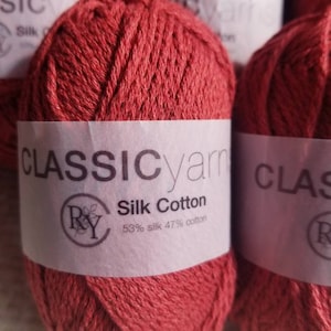 May include: Red yarn skeins labeled "CLASSIC yarn" with a logo and the text "Silk Cotton 53% silk 47% cotton".