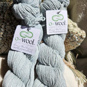 May include: Two skeins of light blue organic wool yarn with a white label that reads "o-wool. organic, it just feels right.  Danney Wool Company"