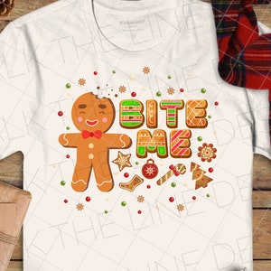 May include: White t-shirt featuring a gingerbread man graphic and the text "Bite Me".