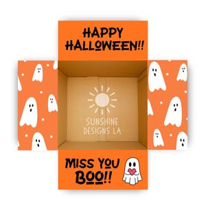 May include: An open cardboard shipping box with orange interior flaps featuring a white ghost pattern. The top flap reads HAPPY HALLOWEEN!! and the bottom flap reads MISS YOU BOO!! with a ghost icon. The center base displays a sun logo and SUNSHINE DESIGNS LA.