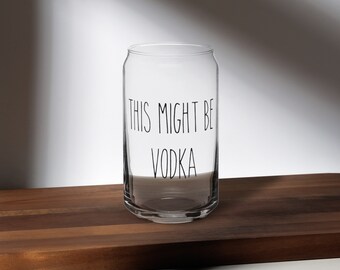 Könnte beinhalten: Ein klares Glasgefäß mit dem Text "This might be vodka" auf der Seite. Das Gefäß steht auf einer Holzoberfläche.