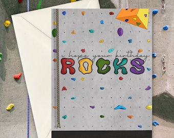 May include: A birthday card with a climbing wall design. The card says "I hope your birthday ROCKS!" in colorful letters.