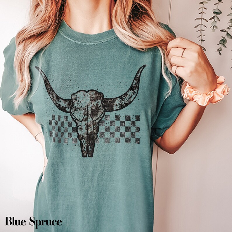 a woman wearing a green shirt with a bull's head on it