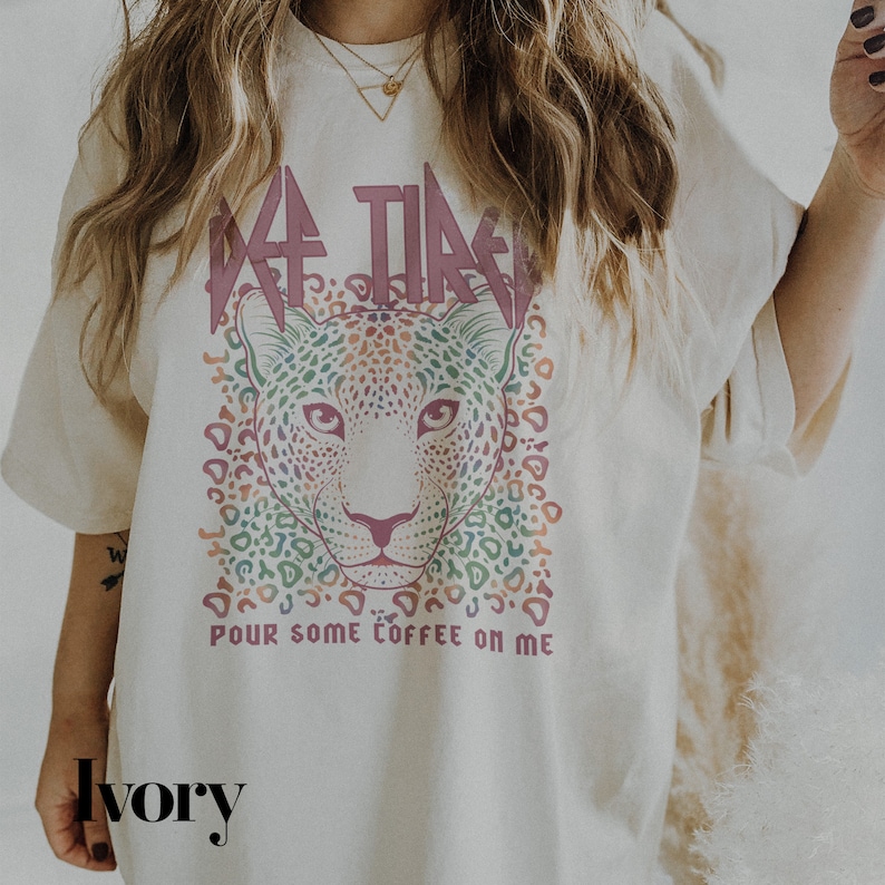 Puede incluir: Camiseta de color marfil con un gr&aacute;fico rosa "Coffee Time" que presenta un dise&ntilde;o de estampado de leopardo colorido y el texto "Pour some coffee on me".