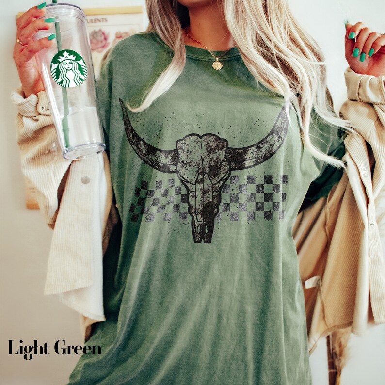 a woman holding a starbucks cup and a starbucks shirt
