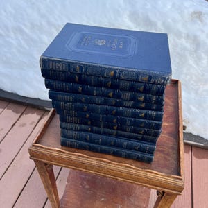 Könnte beinhalten: Ein Stapel von 14 blauen Hardcover-Büchern mit goldenen Schriftzügen auf den Rücken. Die Bücher tragen den Titel "PICTORIAL HISTORY OF THE KOREAN WAR".