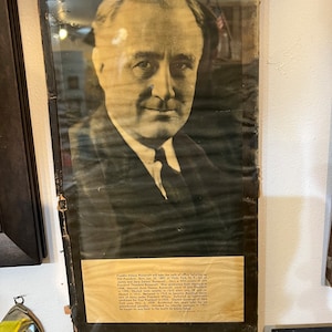May include: A black and white photograph of Franklin Delano Roosevelt, the 32nd President of the United States, taking the oath of office. The photo is framed and includes a caption with biographical information about Roosevelt.