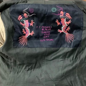 May include: A dark blue patch with embroidered pink dragons and the text "T.J. Kennedy, Tsingtao China 1946, 29th Marines".