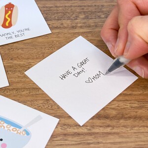 May include: White card with the handwritten message "Have a great day!" and a heart with "Mom" written below it.