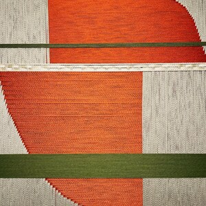 The image is a geometric abstract composition featuring a variety of shapes and colors, including shades of orange, green, and gray.