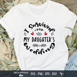 May include: White t-shirt with black text that reads "I survived my daughter's wedding". The text is in a circle with red hearts and stars.
