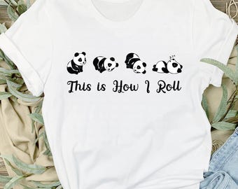 May include: White t-shirt with a black and white panda graphic and the text "This is How I Roll".