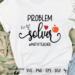 May include: White t-shirt with black text that reads "PROBLEM solver #MATHTEACHER". A red heart and a red apple are next to the word "solver".