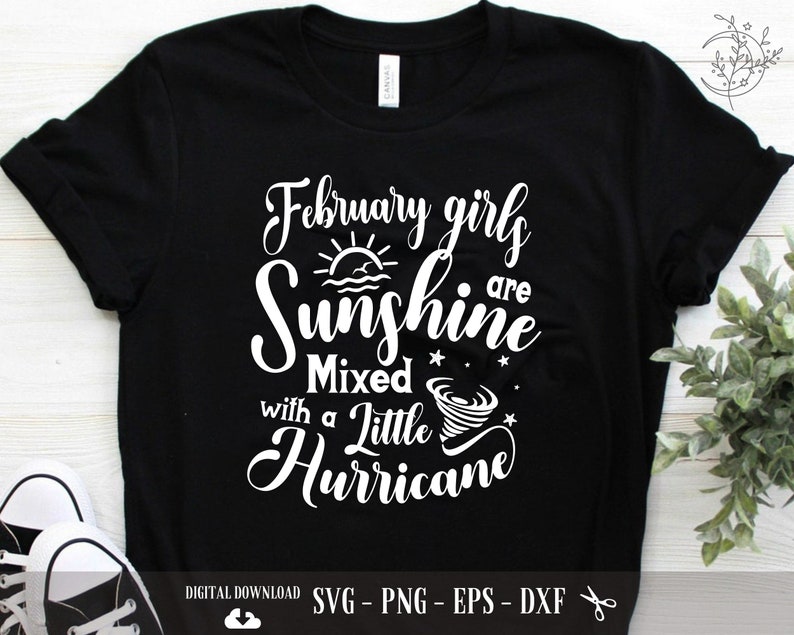 May include: Black t-shirt with white text that reads "February girls are sunshine mixed with a little hurricane". The text is in a cursive font and includes a sun and a tornado graphic.