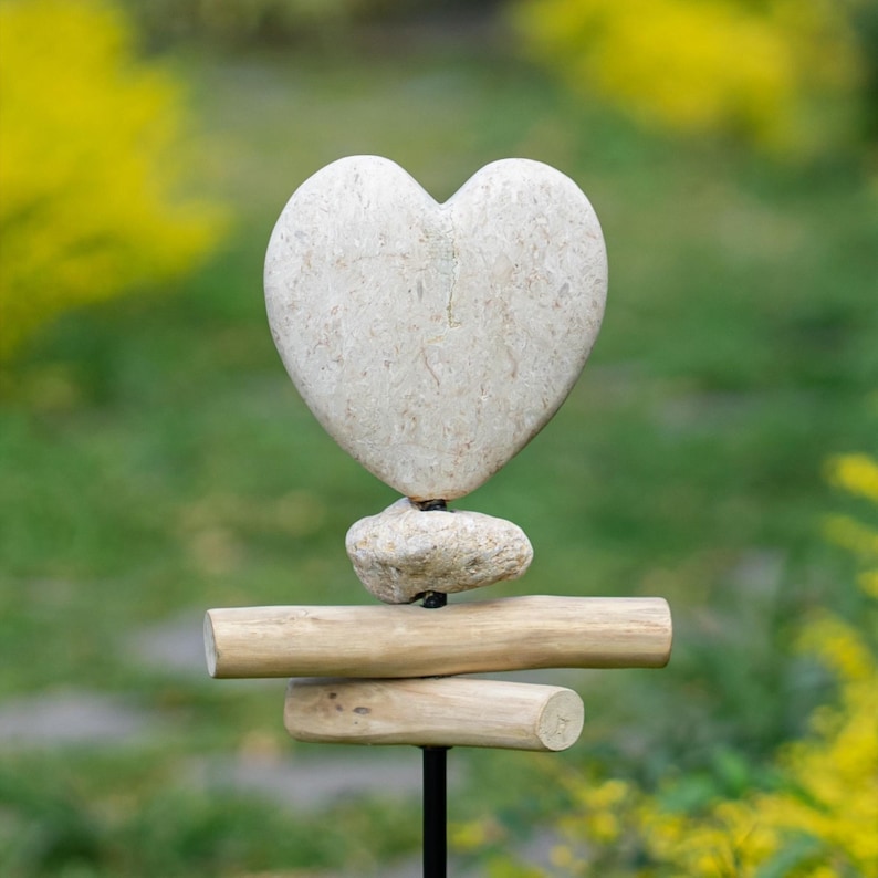 Hand-carved Jasper Stone Heart Harmony Garden Stake featuring a smooth heart shape paired with rustic driftwood on a sturdy metal pole. Each heart is individually carved by hand from genuine Jasper stone, symbolizing love, healing, and grounding energy. A meaningful accent for gardens, memorials, or weddings—this natural outdoor decor piece adds warmth, artistry, and heartfelt charm to any space.