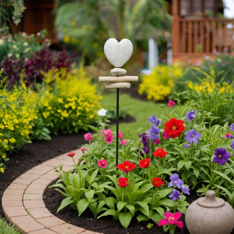 Hand-carved Jasper Stone Heart Harmony Garden Stake featuring a smooth heart shape paired with rustic driftwood on a sturdy metal pole. Each heart is individually carved by hand from genuine Jasper stone, symbolizing love, healing, and grounding energy. A meaningful accent for gardens, memorials, or weddings—this natural outdoor decor piece adds warmth, artistry, and heartfelt charm to any space.