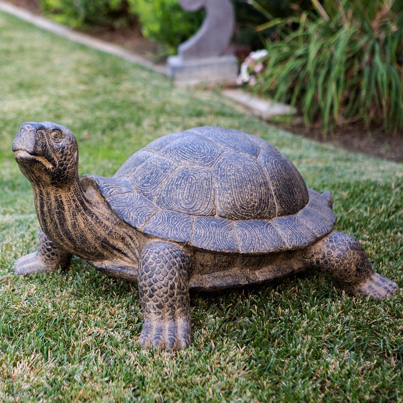 Realistic fiber cement turtle statue available in two sizes, small 14 inch and huge 34 inch life size. Handcrafted with intricate details, the design resembles a sea turtle or tortoise with a textured shell and natural stone-like finish. Perfect for outdoor display in gardens, patios, entryways, or zen spaces, this rustic sculpture is durable, weather resistant, and eco-friendly. A striking yard art figurine and unique gift for turtle lovers and garden enthusiasts.