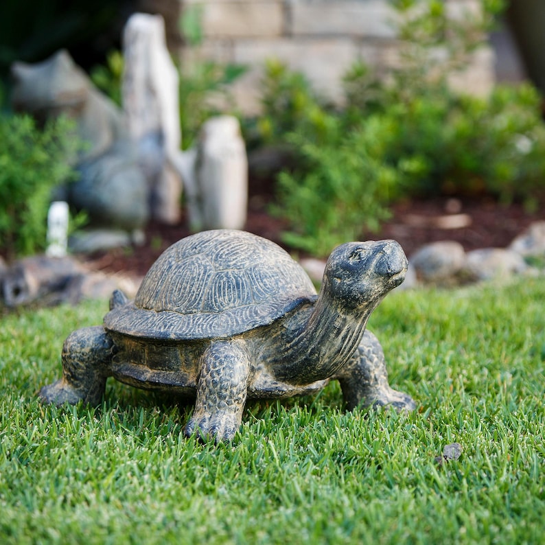 Realistic fiber cement turtle statue available in two sizes, small 14 inch and huge 34 inch life size. Handcrafted with intricate details, the design resembles a sea turtle or tortoise with a textured shell and natural stone-like finish. Perfect for outdoor display in gardens, patios, entryways, or zen spaces, this rustic sculpture is durable, weather resistant, and eco-friendly. A striking yard art figurine and unique gift for turtle lovers and garden enthusiasts.