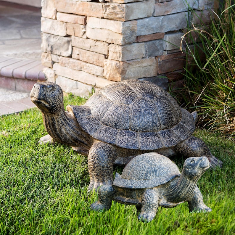 Realistic fiber cement turtle statue available in two sizes, small 14 inch and huge 34 inch life size. Handcrafted with intricate details, the design resembles a sea turtle or tortoise with a textured shell and natural stone-like finish. Perfect for outdoor display in gardens, patios, entryways, or zen spaces, this rustic sculpture is durable, weather resistant, and eco-friendly. A striking yard art figurine and unique gift for turtle lovers and garden enthusiasts.