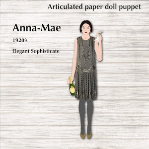 Könnte beinhalten: Gelenkige Papierpuppe einer Frau in einem Flapper-Kleid aus den 1920er Jahren. Die Puppe hält in der einen Hand eine Champagnerflasche und in der anderen ein Taschentuch. Die Puppe ist mit "Anna-Mae" und "Elegante und raffinierte" beschriftet.
