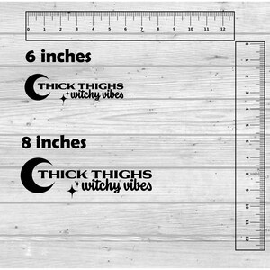 May include: Two black and white vinyl decals with the text "THICK THIGHS + witchy vibes" and a crescent moon. The decals are shown on a wood background with rulers measuring 6 inches and 8 inches.