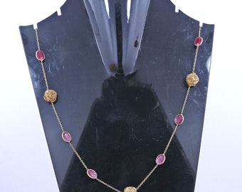 May include: A gold chain necklace with pink oval-shaped gemstones and gold wire ball accents.