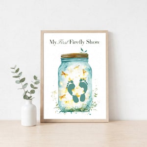 May include: A framed wall art print featuring a glass mason jar filled with glowing yellow fireflies and a pair of dark green baby footprints in the center. The text My First Firefly Show is printed in black at the top of the white background.