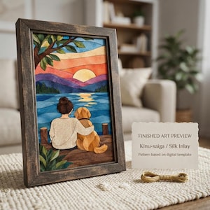 May include: A framed art piece featuring a watercolor-style illustration of a person and a golden dog sitting on a wooden dock overlooking a lake at sunset. The scene includes mountains, a bright sun, and trees. Text reads: FINISHED ART PREVIEW Kinu-saiga / Silk Inlay Pattern based on digital template.