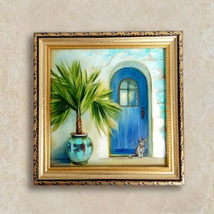 Può includere: Dipinto incorniciato quadrato raffigurante una scena mediterranea. Una porta blu con una piccola finestra è incastonata in un muro bianco. Una palma in vaso e un gatto grigio sono in primo piano. La cornice è dorata con un bordo decorativo.
