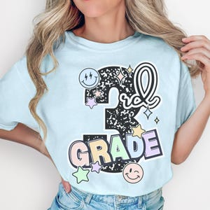 a woman wearing a t - shirt that says 5th grade