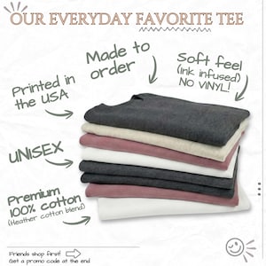 The image is an advertisement for a "Our Everyday Favorite Tee" featuring a stack of various colored shirts, including black, gray, pink, and white. The text highlights the shirt's features, such as being made in the USA, unisex, premium cotton, and no vinyl. The ad also mentions that friends shop first and provides a promotion code at the end.