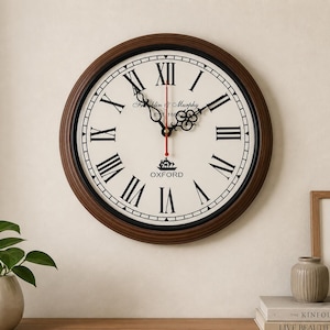 Puede incluir: Un reloj de pared redondo con un marco de madera marrón oscuro y una esfera color crema. El reloj presenta números romanos negros, manecillas negras y el texto "Franklin & Murphy EST. 1866" y "OXFORD". El segundero es rojo.