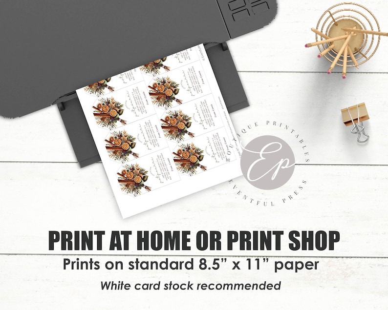 May include: A printer is shown printing a sheet of labels with a floral design featuring oranges and cinnamon sticks. The text on the labels is in a script font. The image also includes the text "PRINT AT HOME OR PRINT SHOP".